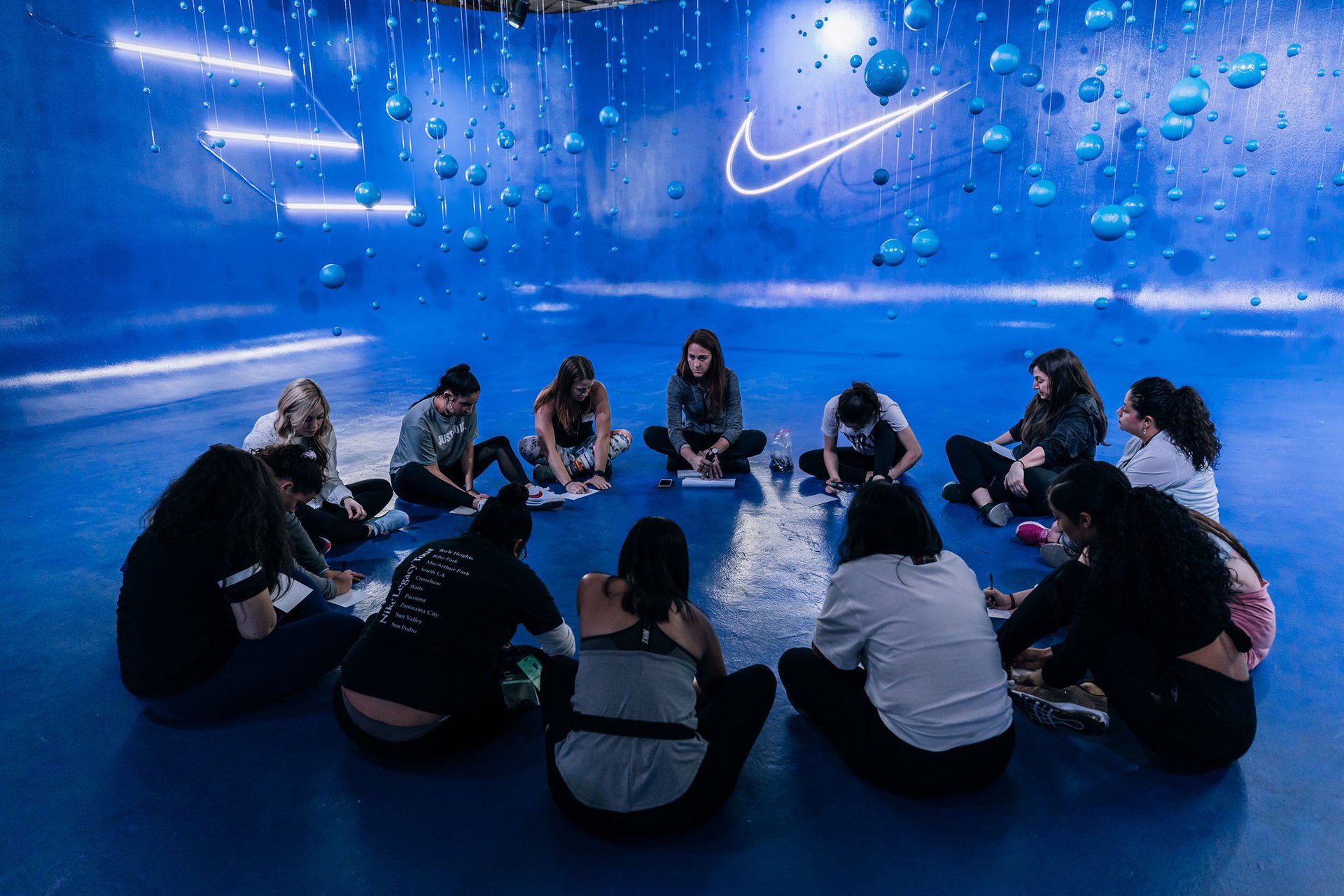 A group of women seated at Nike Women Coach LA, an event with the purpose of empowering girls through sports. 