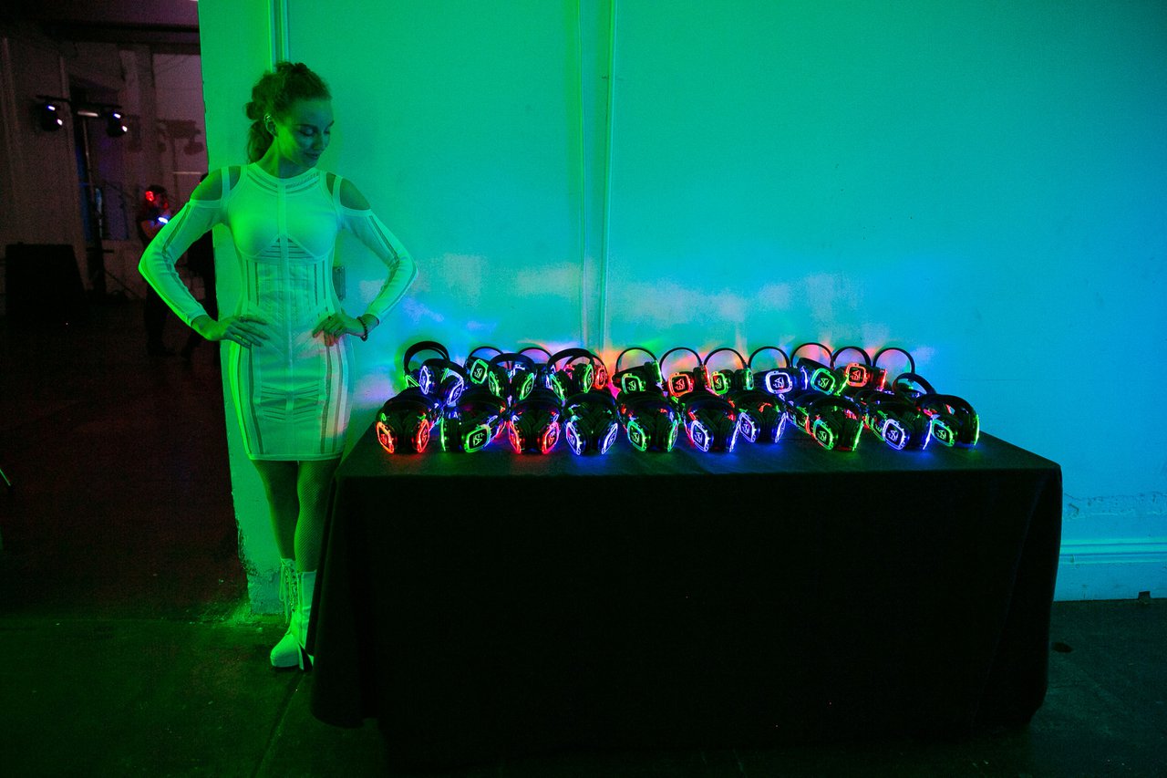 Woman standing next to neon headphones