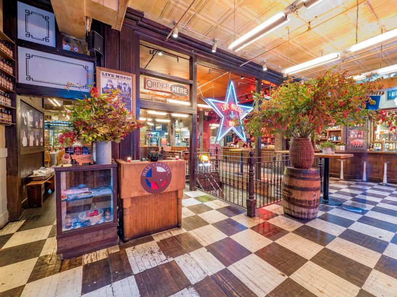 A big barbeque restaurant with black and white checkered floors and large statement floral arrangements