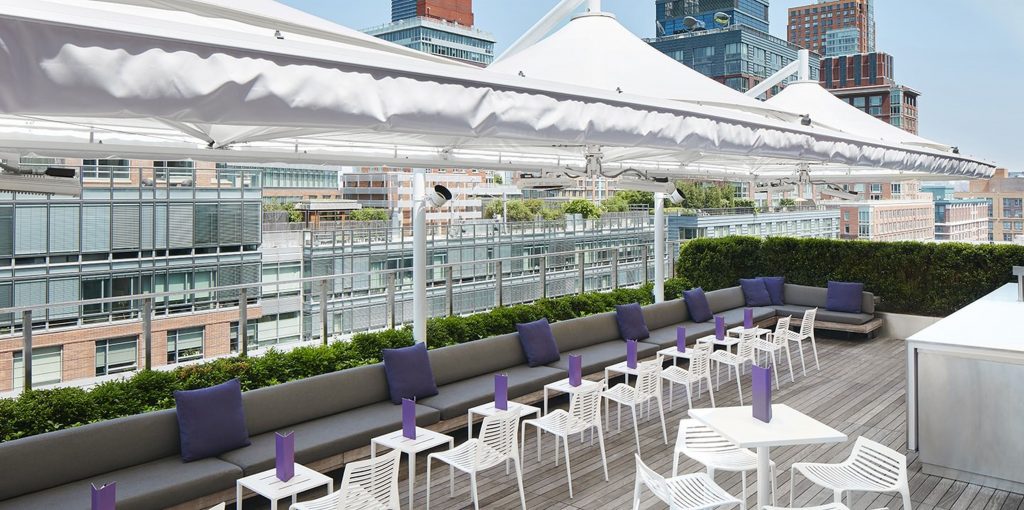 Rooftop venue with white tables and chairs and white tent overhangs