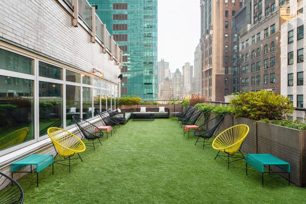Rooftop deck with astroturf grass and colorful chairs