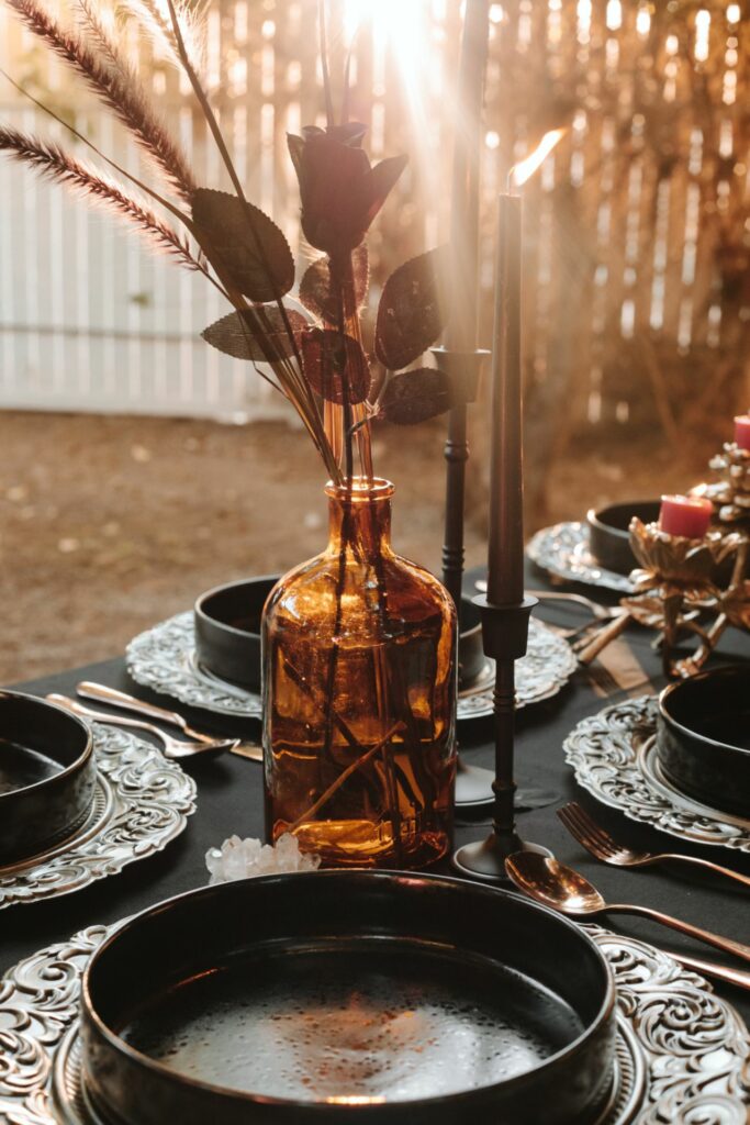 A fall table setting with black tablecloth and black candlesticks