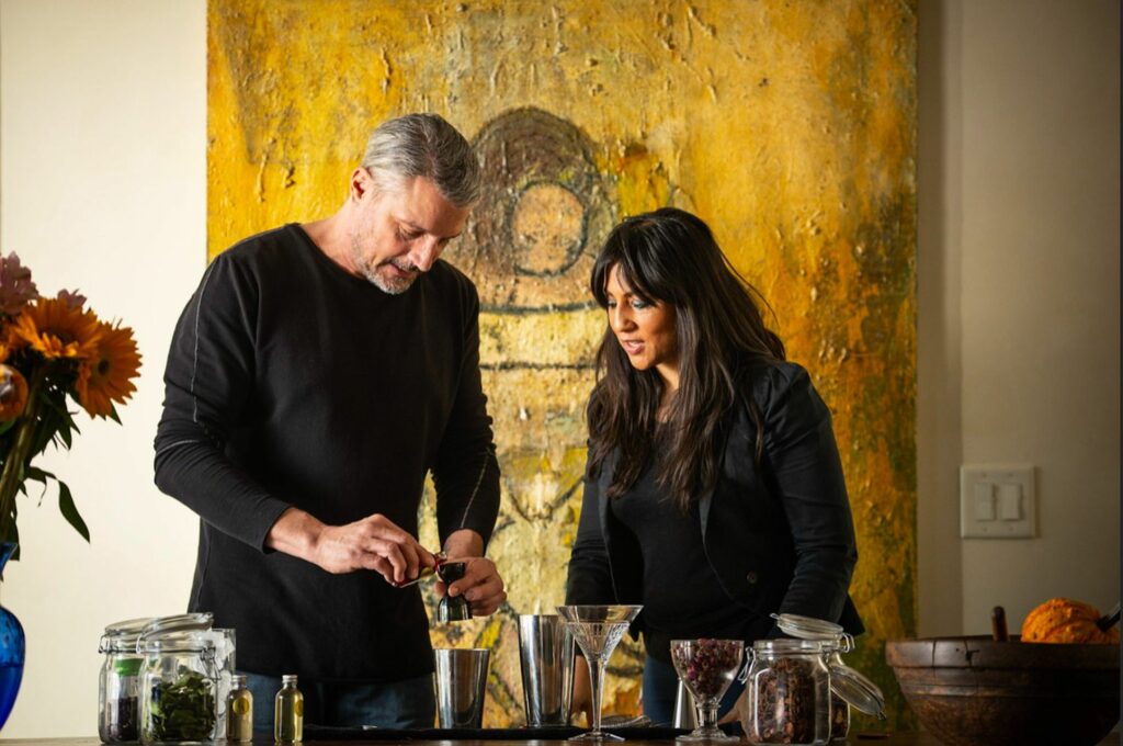 Man and a woman standing over cocktail making glasses