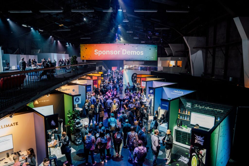 Large venue at a conference with people milling about booths