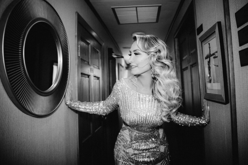 Woman standing in a hallway in a sparkly dress