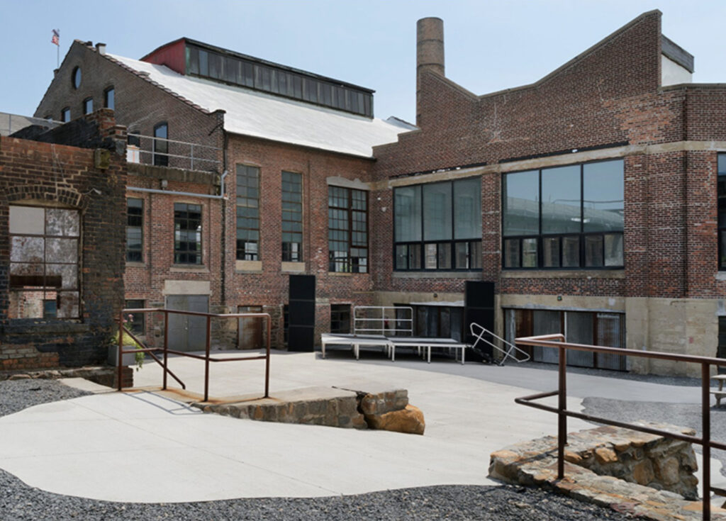 Large facade of industrial building with outdoor sidewalk space