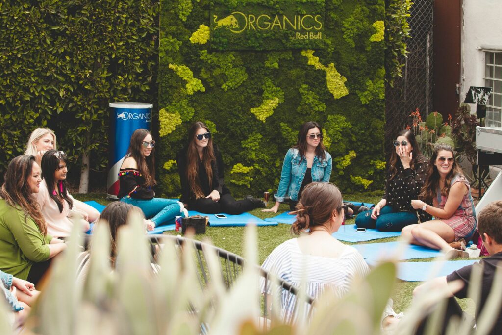 A group of women sitting in a circle on yoga mats talking