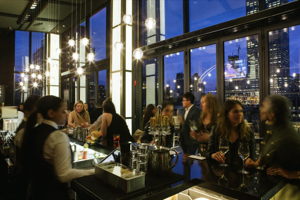 Bar at night in high rise with city views 