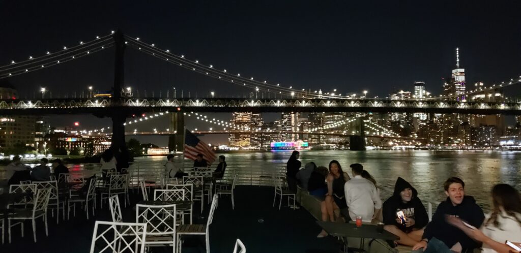 Open air yacht looking out at an nighttime NYC skyline