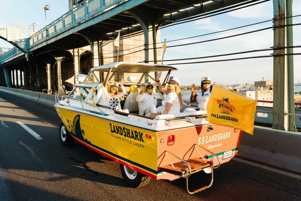 A boat on wheels driving across a bridge