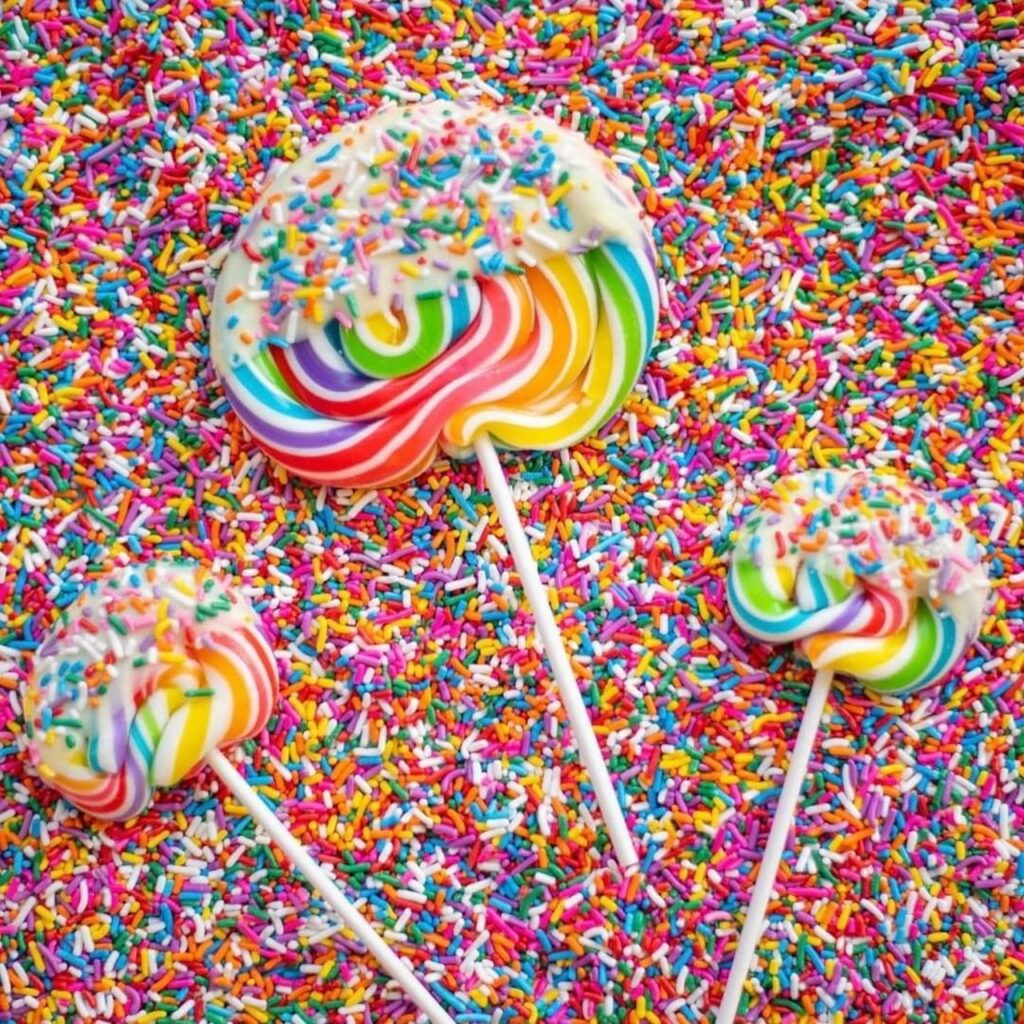 Lollipops sitting in a bed of sprinkles