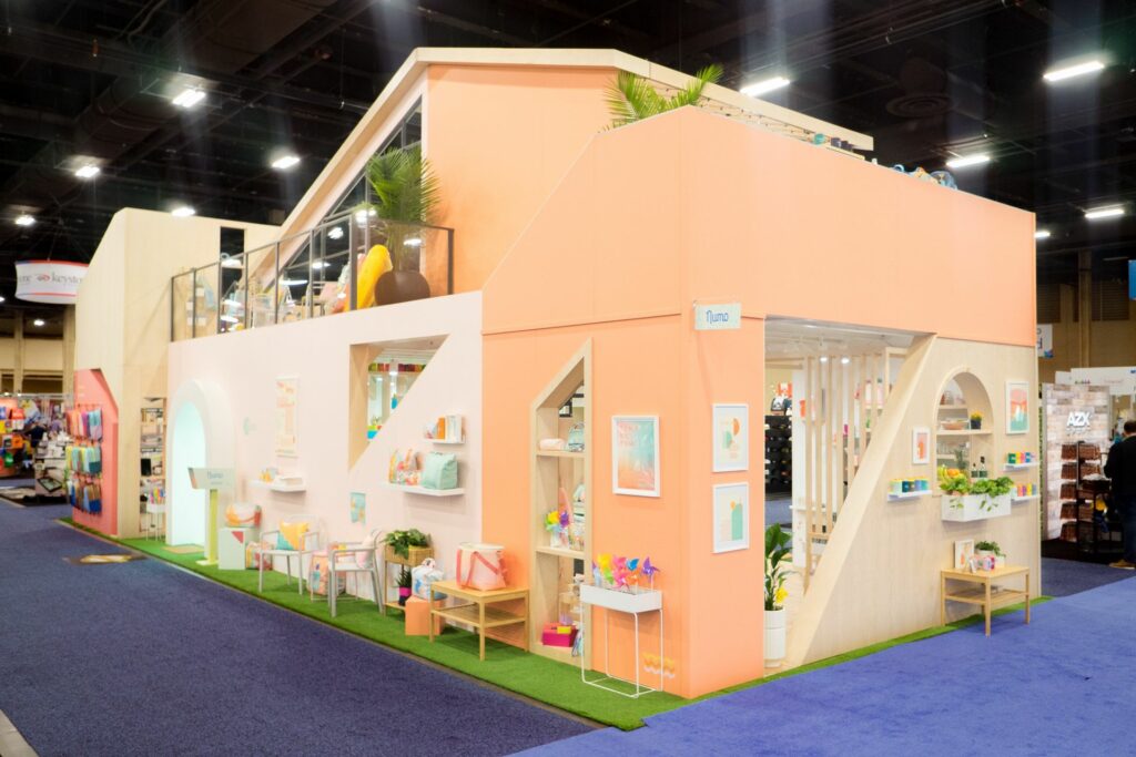 A large booth at a conference fabricated like a bright colorful house
