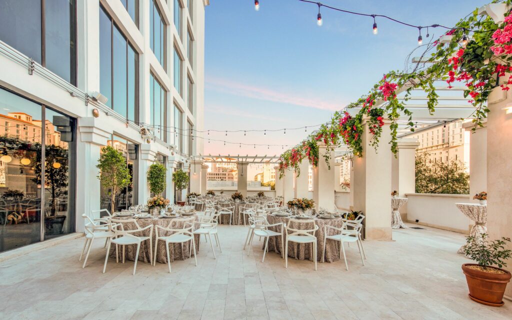 Outdoor rooftop in all white with hanging flowers on a gazebo