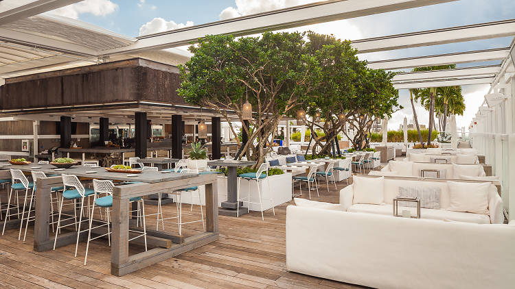 Sprawling outdoor restaurant flanked with white couch lounge areas