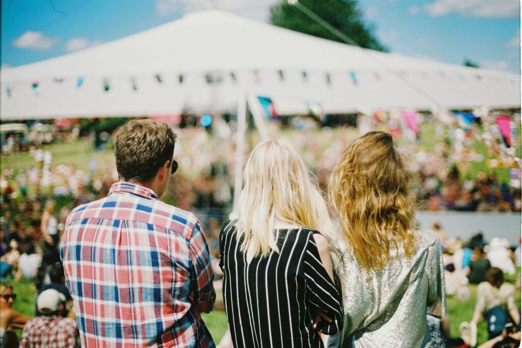 Three people looking out to a large yard with a tent