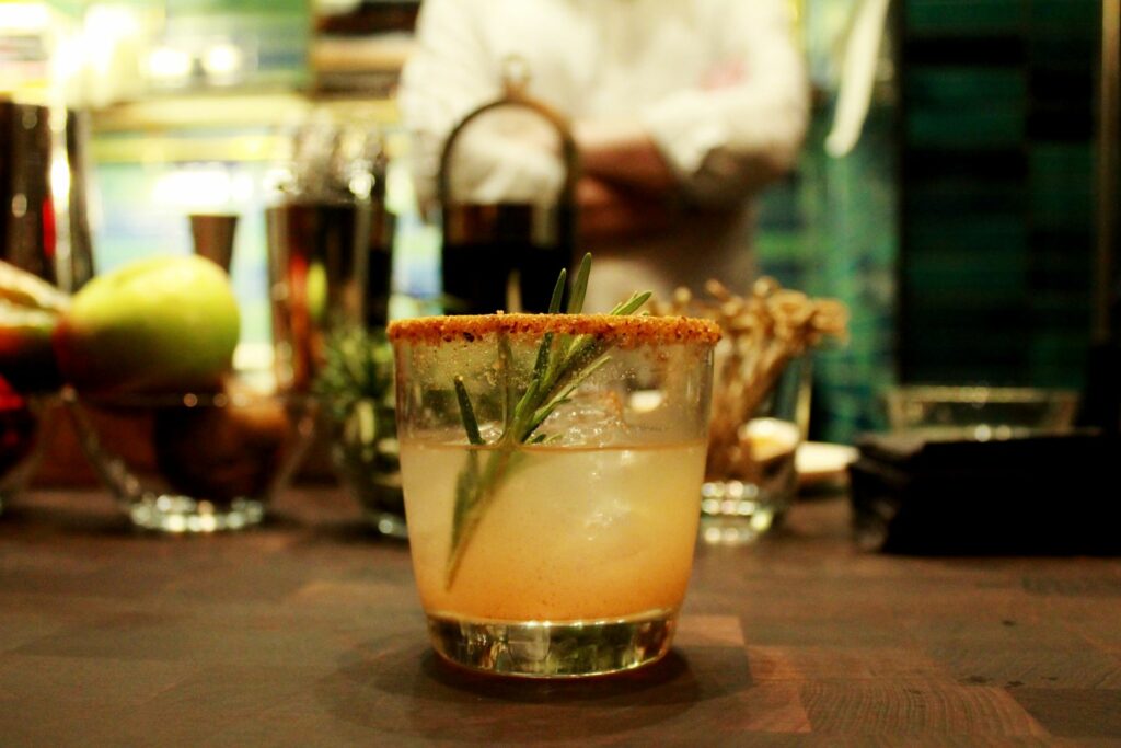 A cocktail with a salt rim and a sprig of rosemary