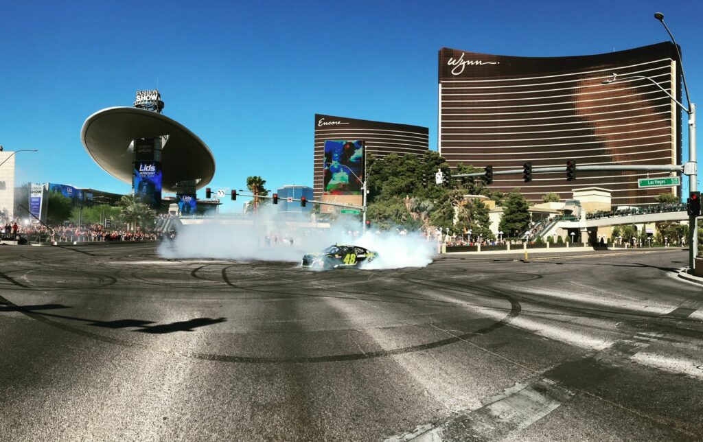 A race car in the middle of a roundabout with smoke coming from tires