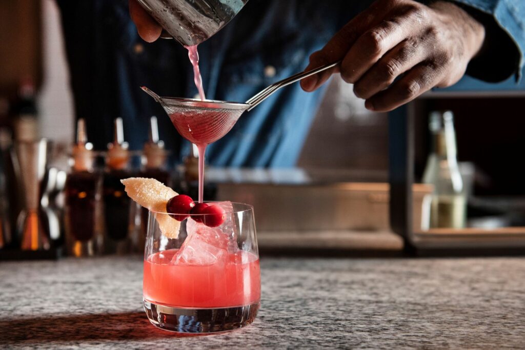 A cocktail being prepared and strained