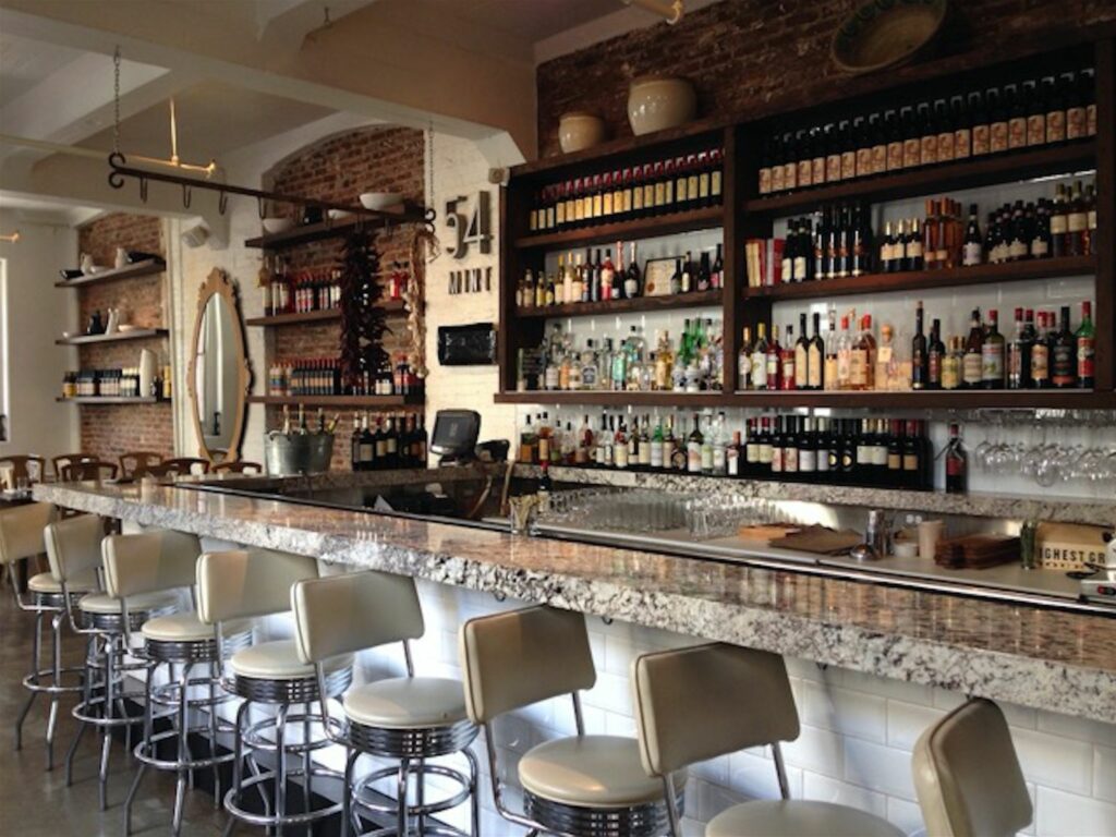 Long marble bar with tall cream colored bar stools 