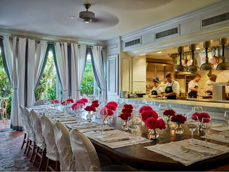 A large dining table by an open kitchen