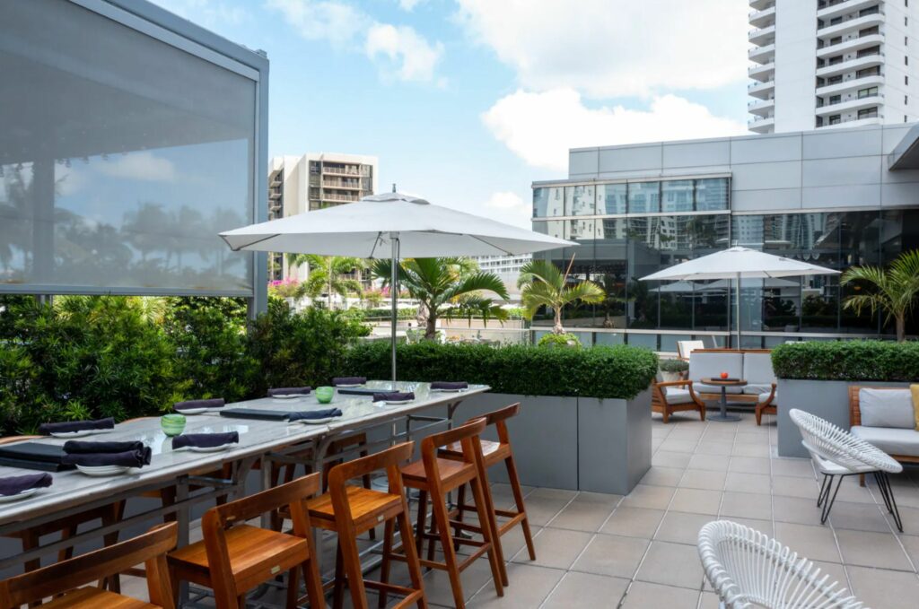 A rooftop restaurant space with tables, chairs, and lounge seating