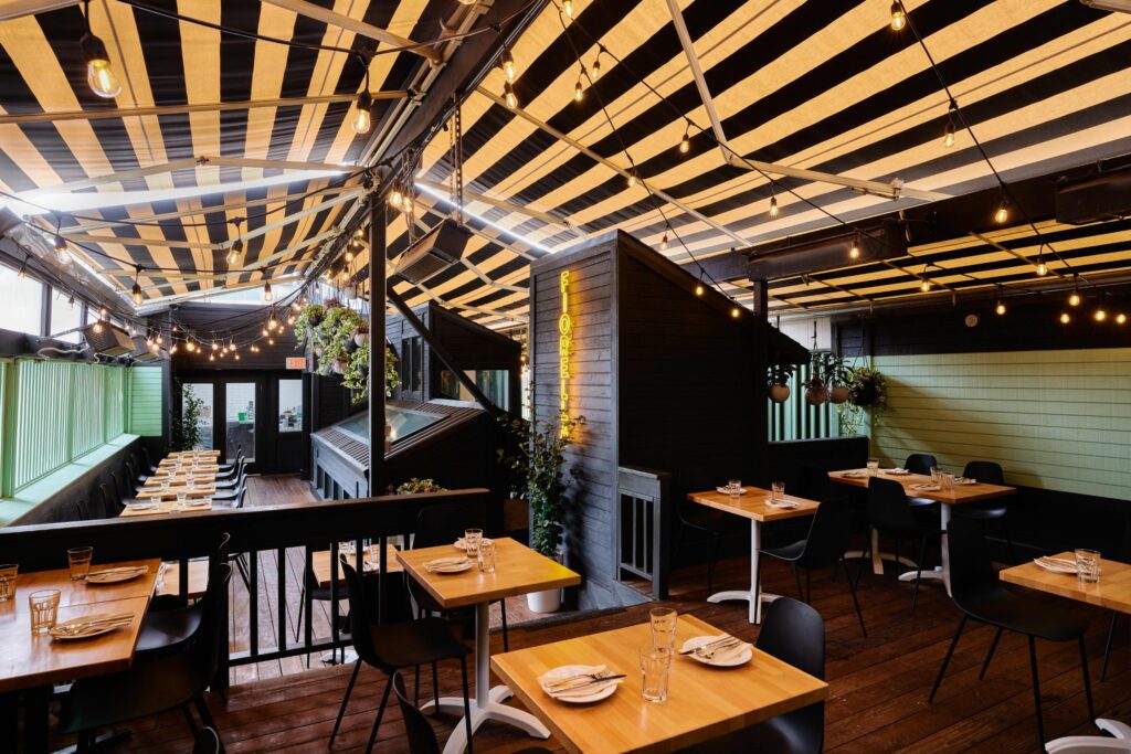 Enclosed rooftop bar with striped awning