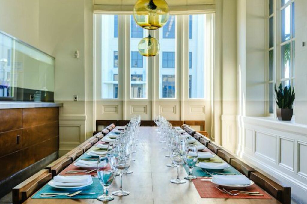 Long dining table set with plates and wine glasses