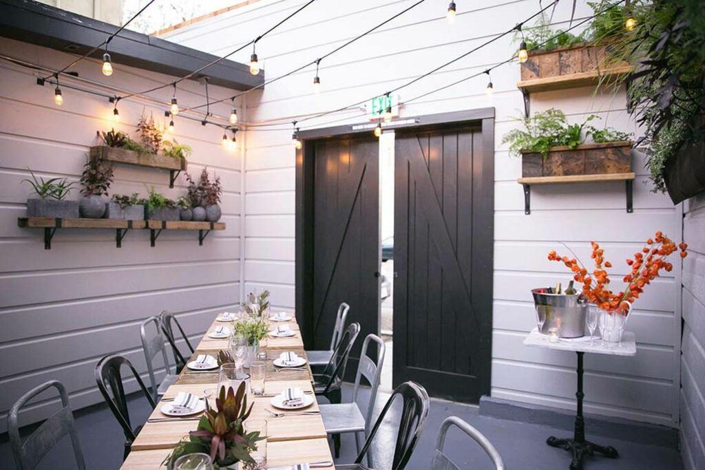 Enclosed patio with wooden tables and string lights