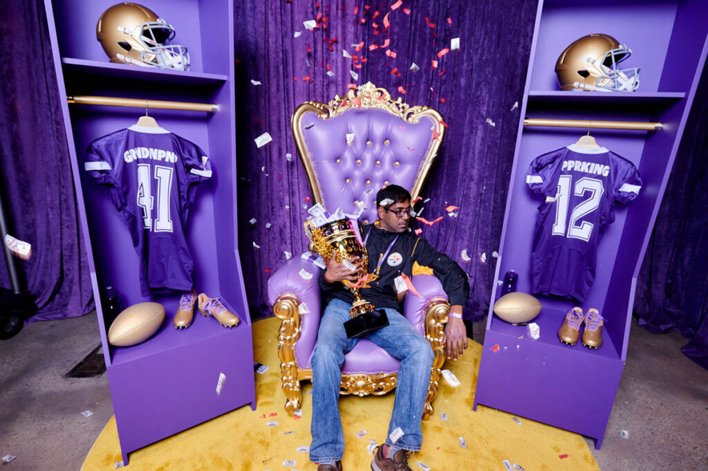 A man sitting on a throne with a large trophy