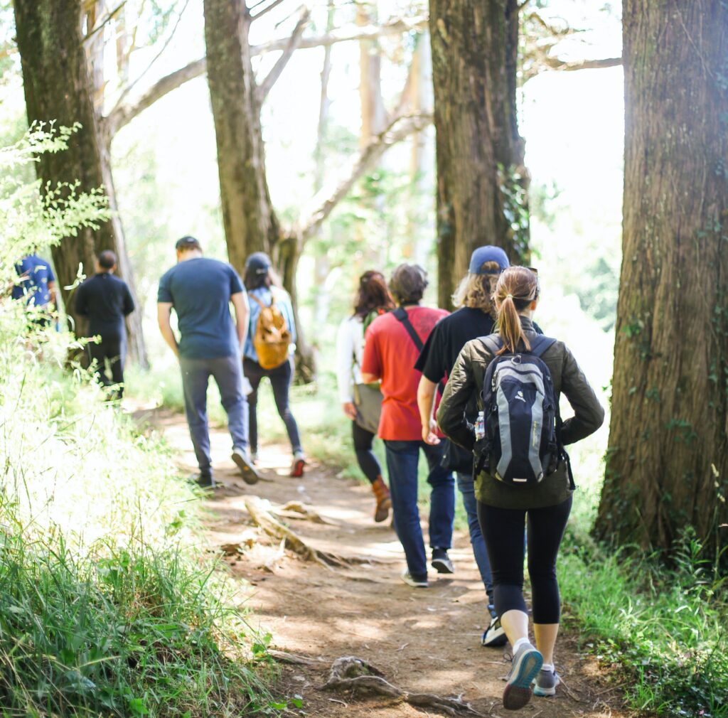 Group of people hiking together on a trail at a company retreat 