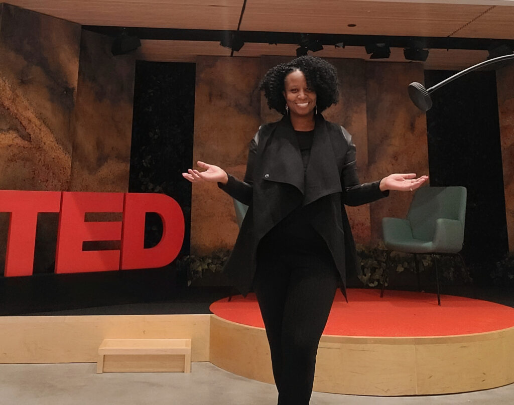 Monique Ruff-Bell in front of a stage set up for a TED conference 