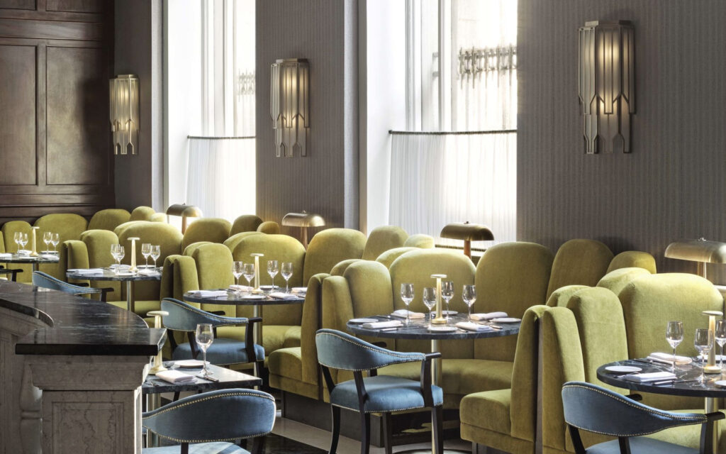 Café Riggs dining room with lush green booths and blue accent chairs