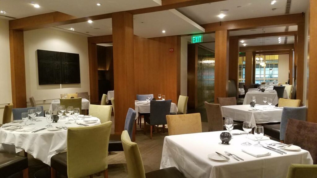 Corduroy restaurant in Washington D.C. with multi-colored chairs and white tablecloths