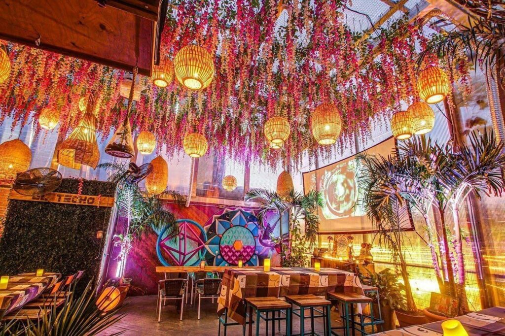El Techo rooftop bar with hanging floral installations and warm lighting