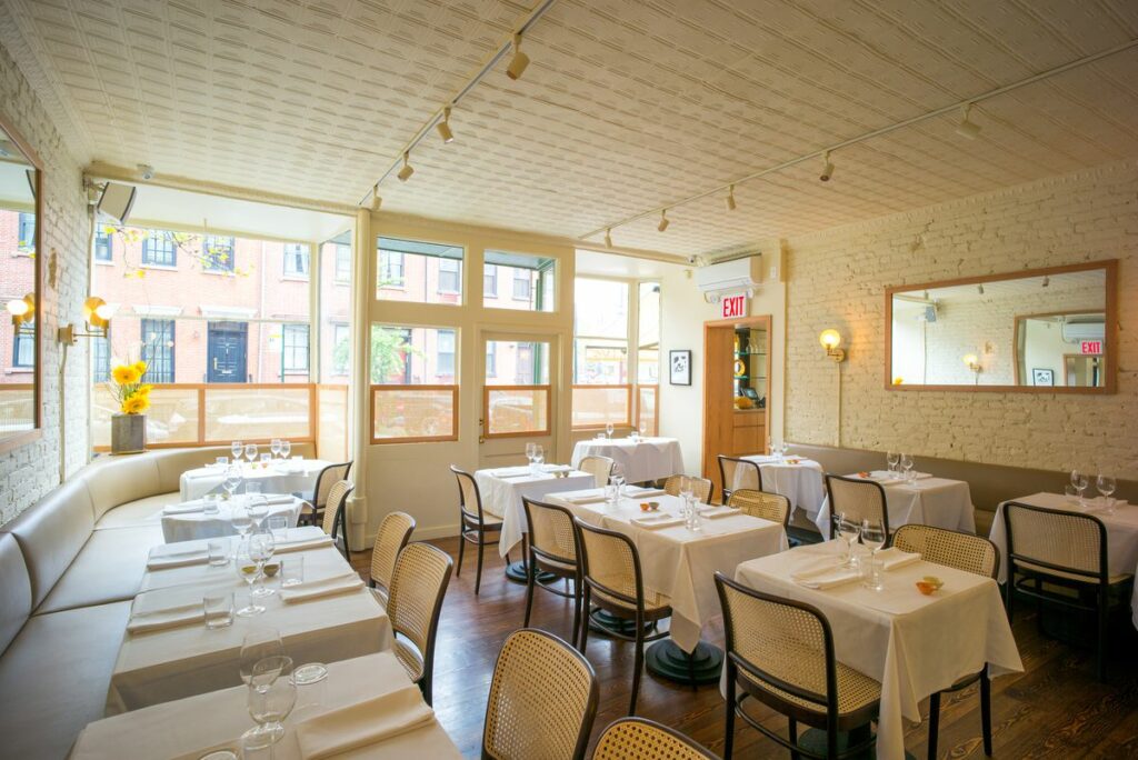 King restaurant with large windows and white table cloths 