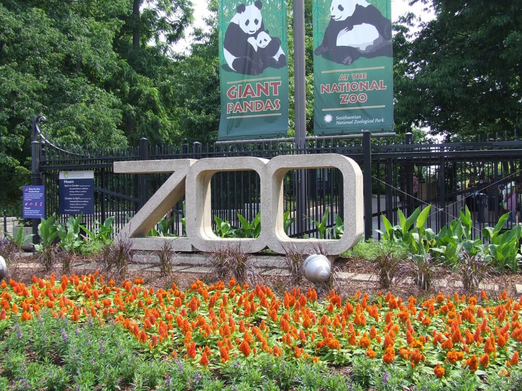 The entrance to the Smithsonian National Zoo & Conservation Biology Park with florals, greenery, and a large Zoo sign 