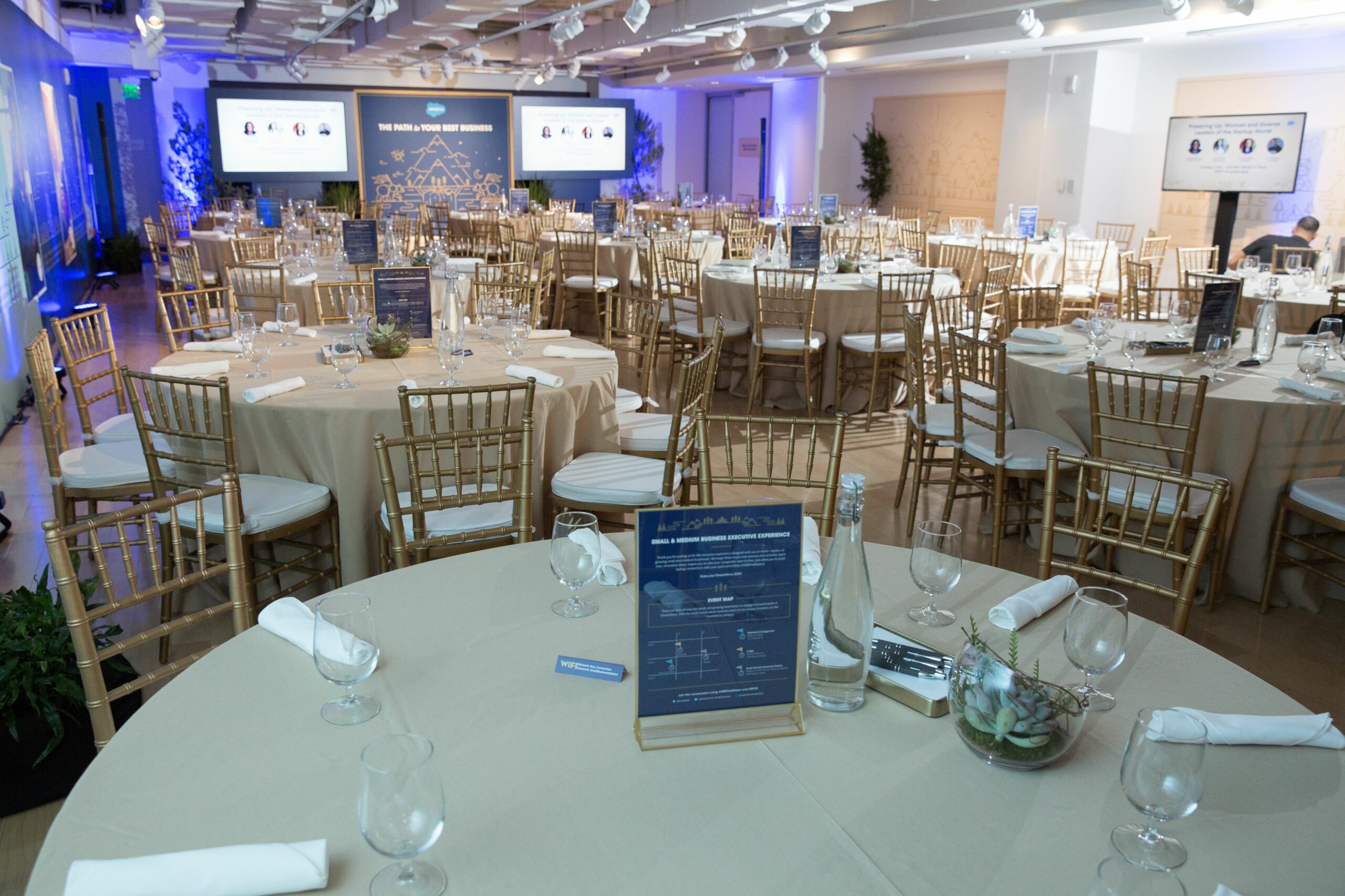 Large room with tables and chairs set up for a Salesforce event