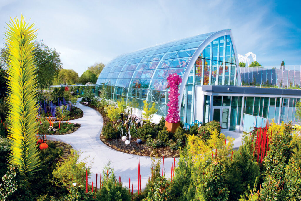 Chihuly Garden and Glass in Seattle, a greenhouse building surrounded by lush plants and flowers