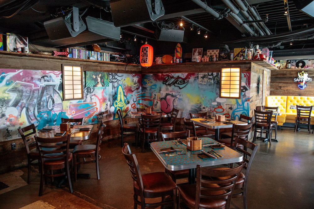 Hojoko in Boston with dining table seating and graffitied walls