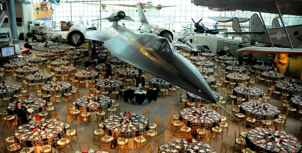 Museum of Flight in Seattle set for an event with dozens of large round tables among large parked planes