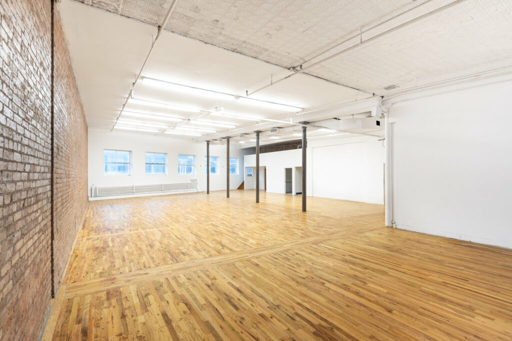 Sixth Floor Loft in NYC with wooden flooring and an exposed brick wall