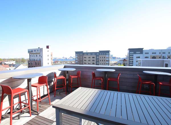 Cunard Tavern's rooftop deck in Boston with high boys and red chairs