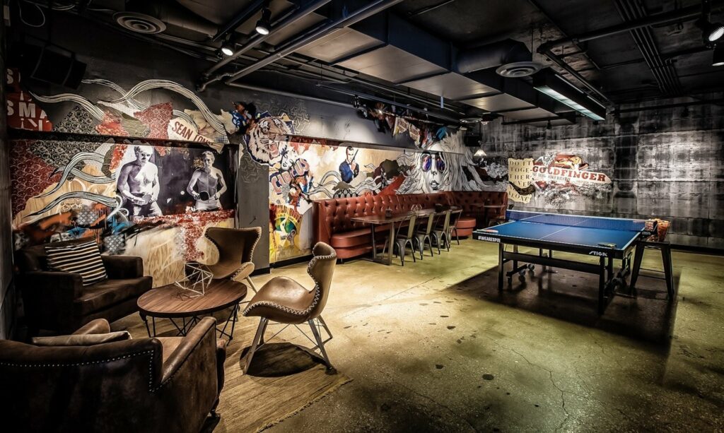 SPiN Chicago venue  with murals on the walls and a large ping pong table