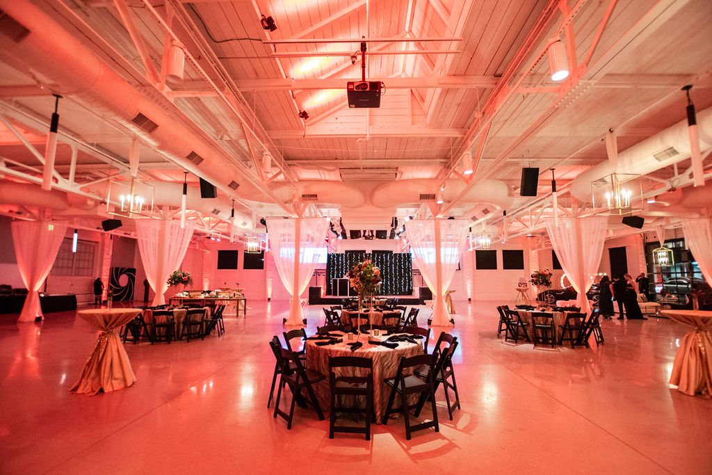 Venue with pinkish red lighting and white walls 