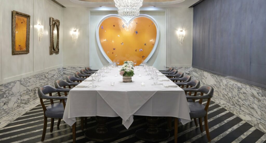 Cecconis dining room area with yellow heart wall installation