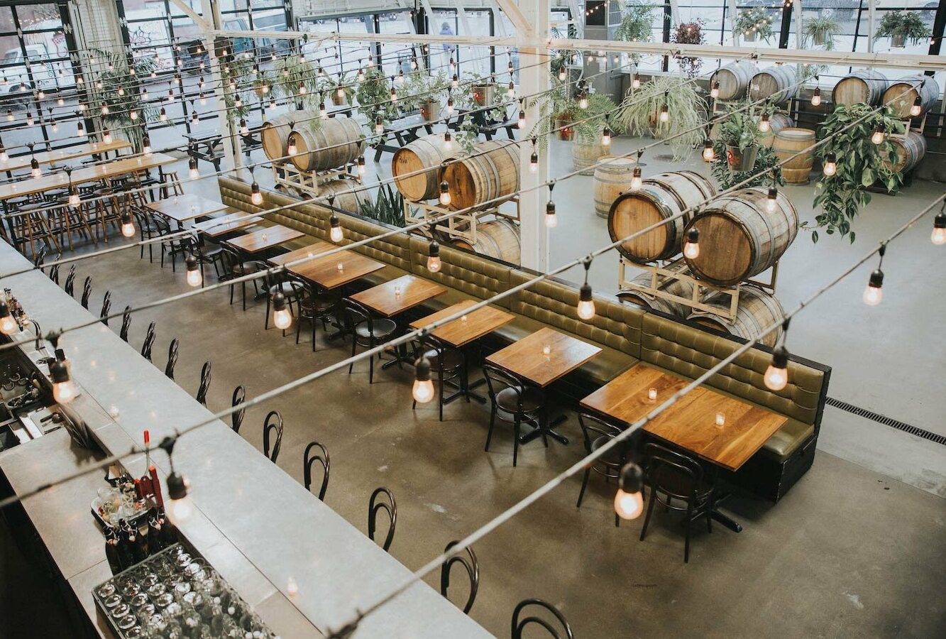 Large winery with natural light, two-story ceilings, and bursts of greenery.
