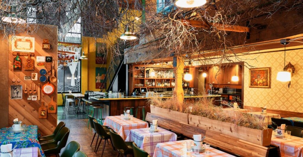 Private dining room with plaid table cloths and tree branch like ceiling installations 