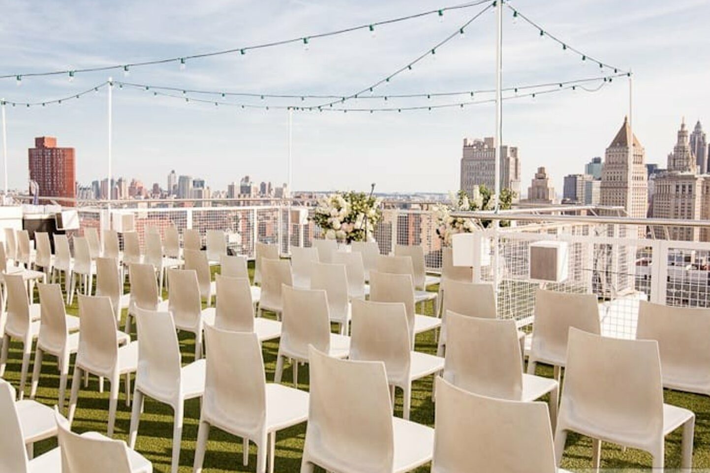 Nomo Soho rooftop with white chairs arranged and city view