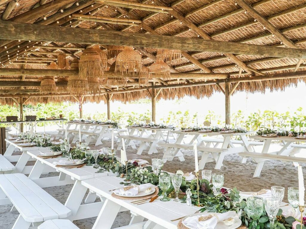 Palm House in Miami with white picnic tables and a covered outdoor area