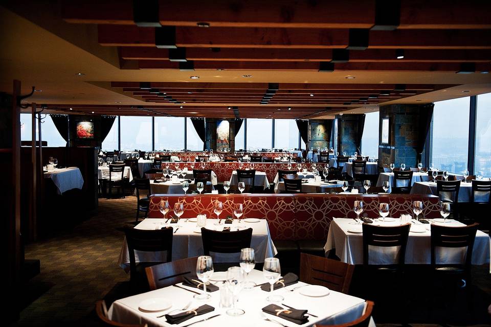 private dining room with dim lighting and white and red table cloths